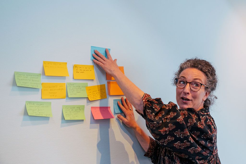 Caroline Pickard begeleidt een Active Bystander training en werkt met post-its op een whiteboard