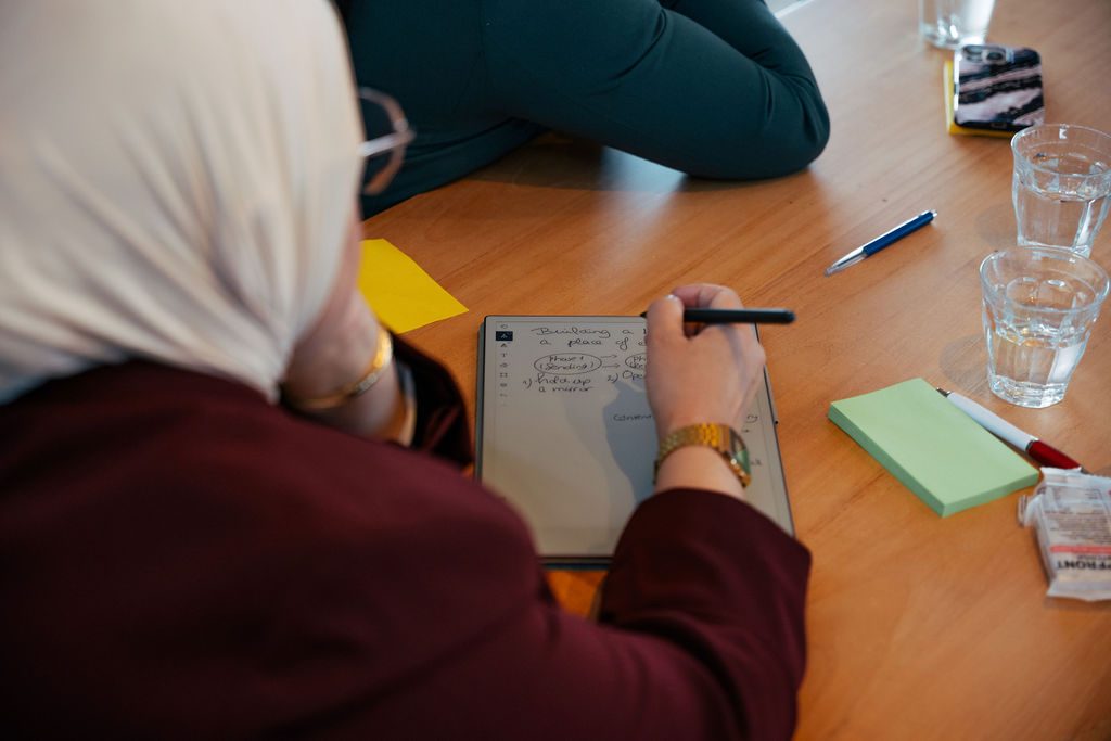 Deelnemer maakt aantekeningen tijdens een workshop, &lsquo;Building a bridge from a place of empathy&rsquo;
